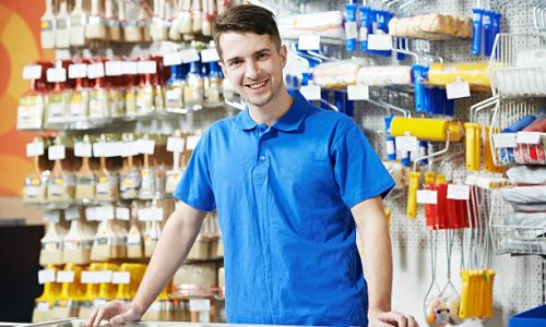 Happy seller assistant man in DIY hardware or home improvement store